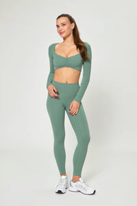 Model wearing Базові легінси темно-зеленого кольору with high waist and smooth seamless design.