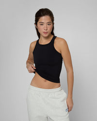 Майка без чашок чорного кольору, облягаючий силует, безшовна, з високою горловиною, на моделі фронтальний ракурс