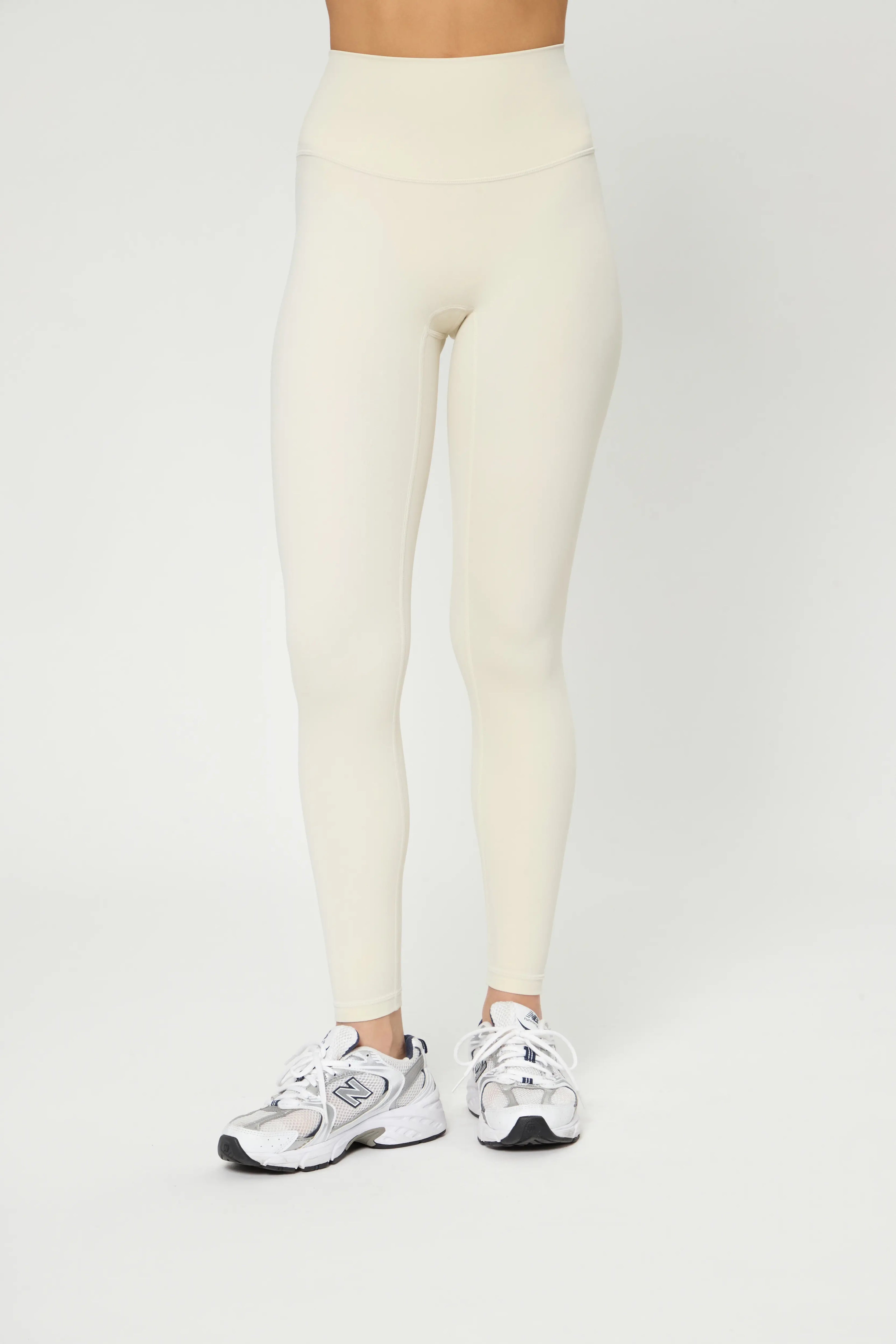 Базові легінси молочного кольору with high waist, smooth front, flat seams, and breathable elastic soft fabric for comfort.