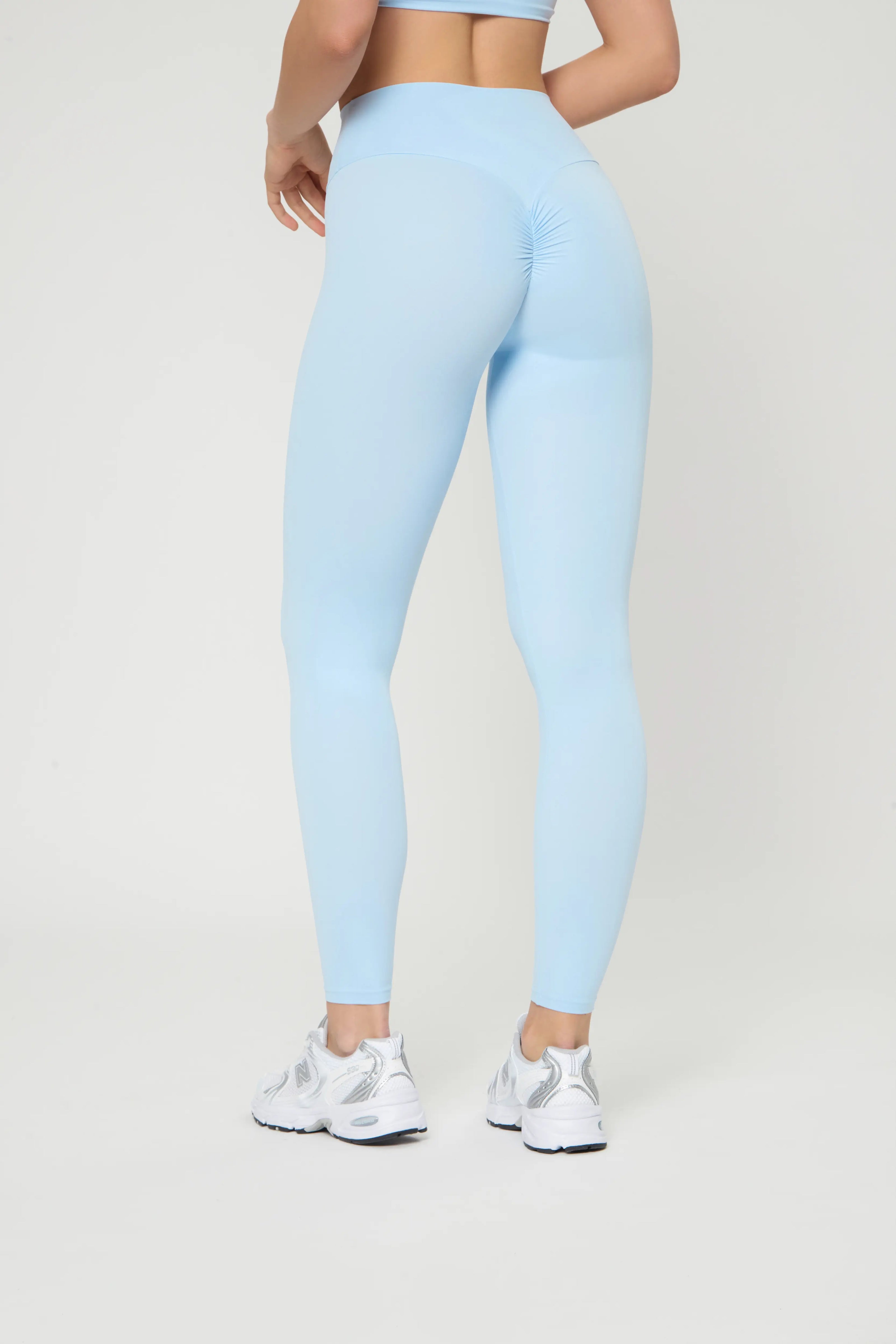 Push-up легінси блакитного кольору with high waist and seamless design highlighting toned legs and curves.