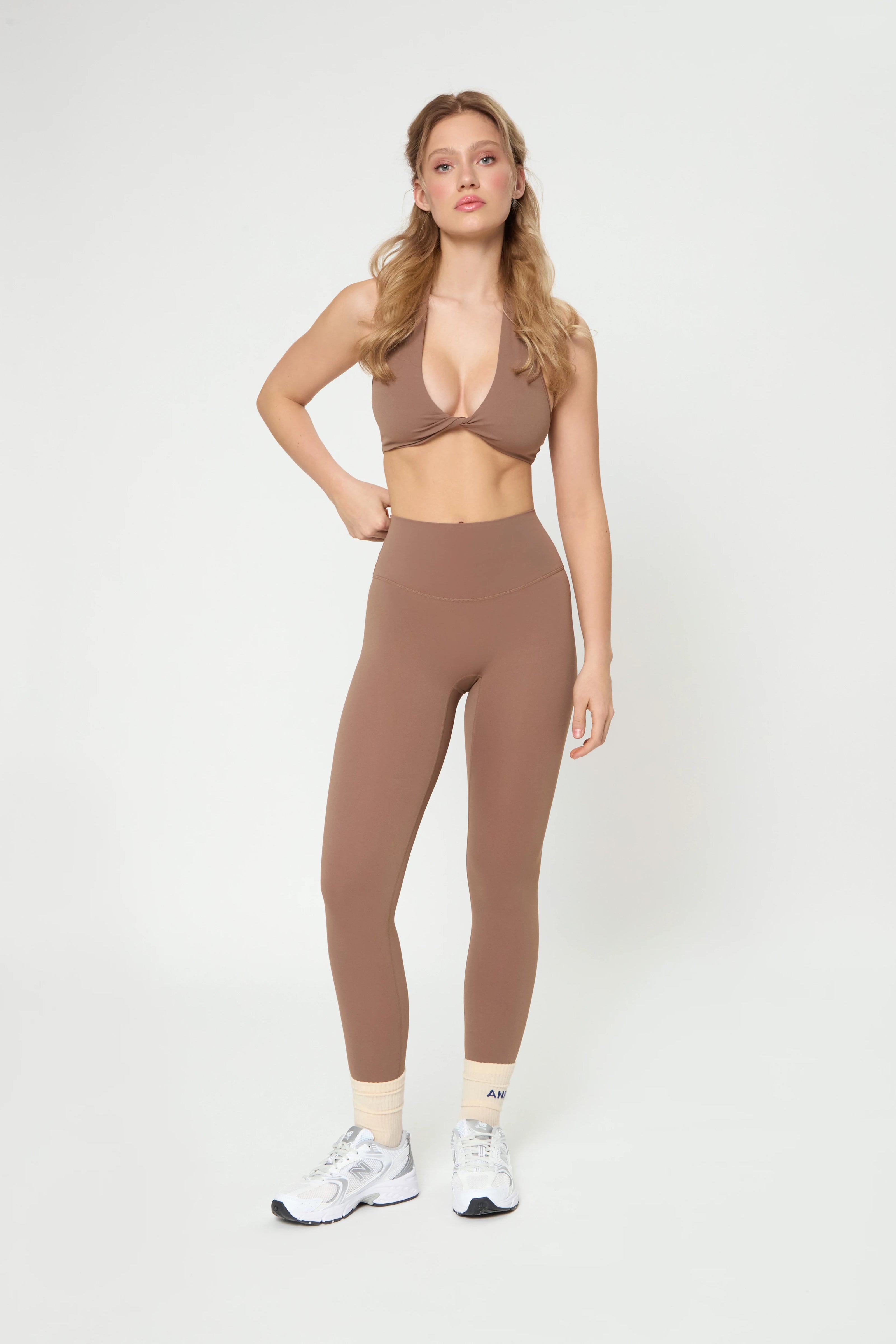 Woman wearing Базові легінси кольору мокко high-waisted leggings with wide waistband and no front seam.