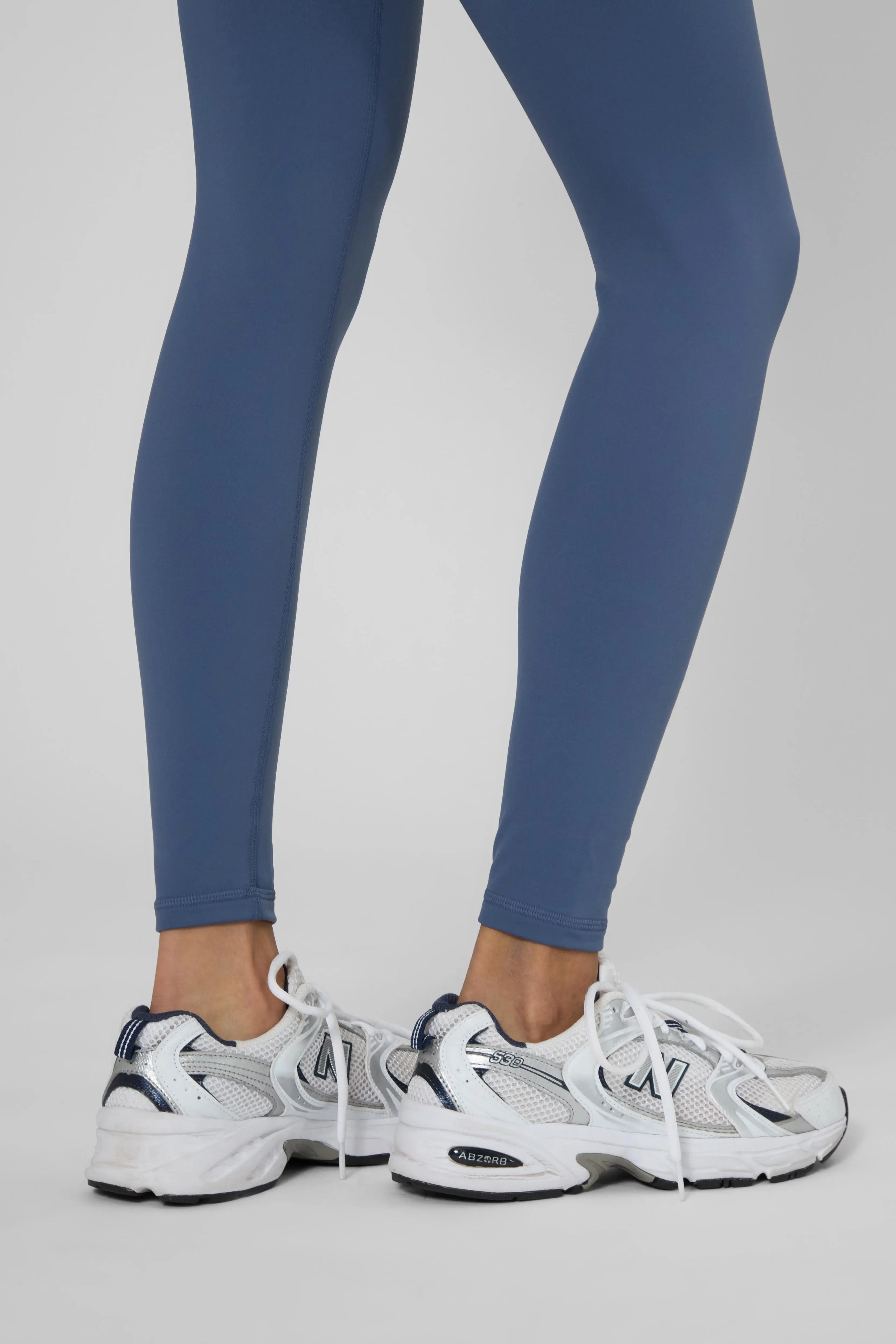 Утеплені базові легінси з начосом синього кольору, прямий ракурс, щільна та еластична тканина, довжина до щиколотки.